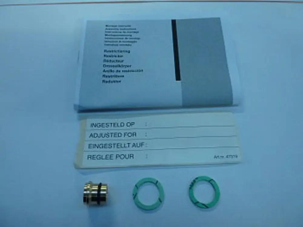 Remeha Produktbestandteile: ein metalldrehbarer Abschnitt, zwei grüne O-Ringe und eine Bedienungsanleitung in mehreren Sprachen. Anleitungen sind bedruckt mit Zusatzinformationen.